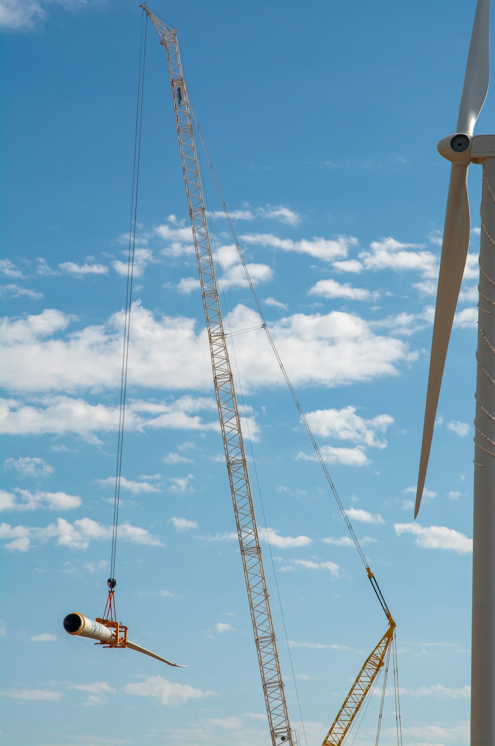 a crane is lifting a wind turbine into place