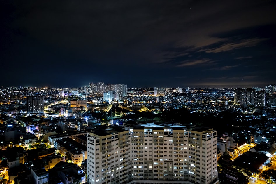 Ho Chi Minh City skyline illuminated at night with towers reflected in the Saigon River