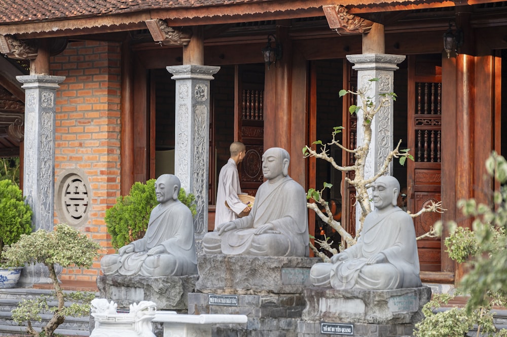 a group of statues of buddhas in front of a building