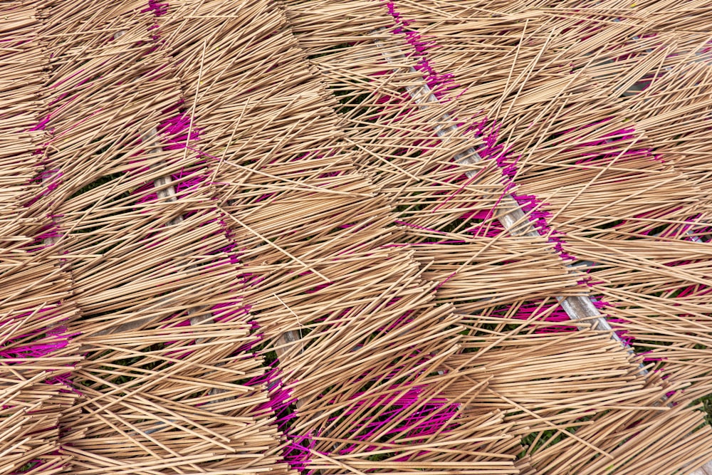 a bird sitting on top of a straw covered umbrella