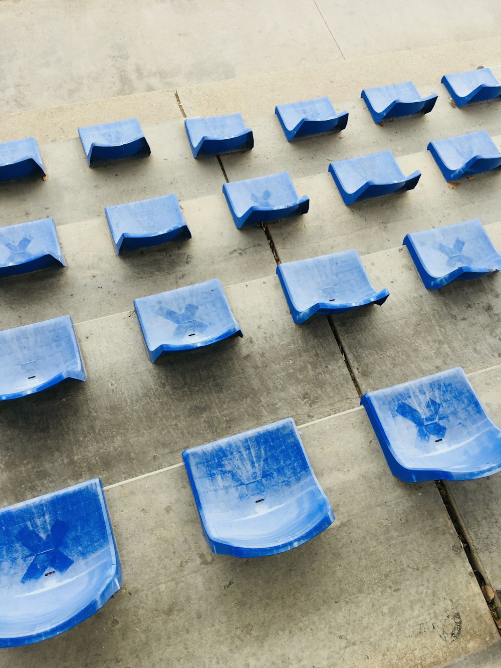 a bunch of blue seats sitting on a sidewalk