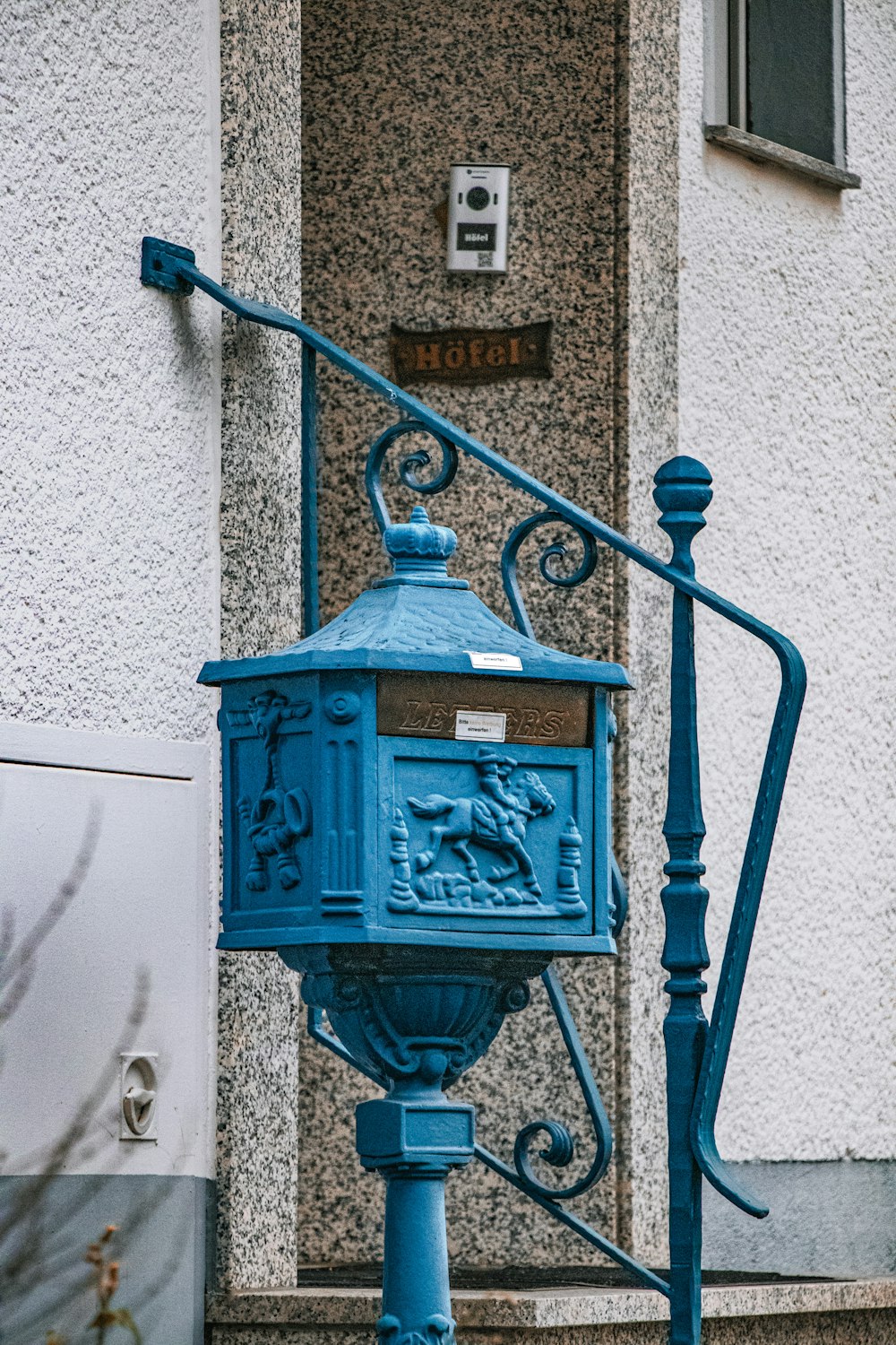 a blue mailbox sitting on the side of a building