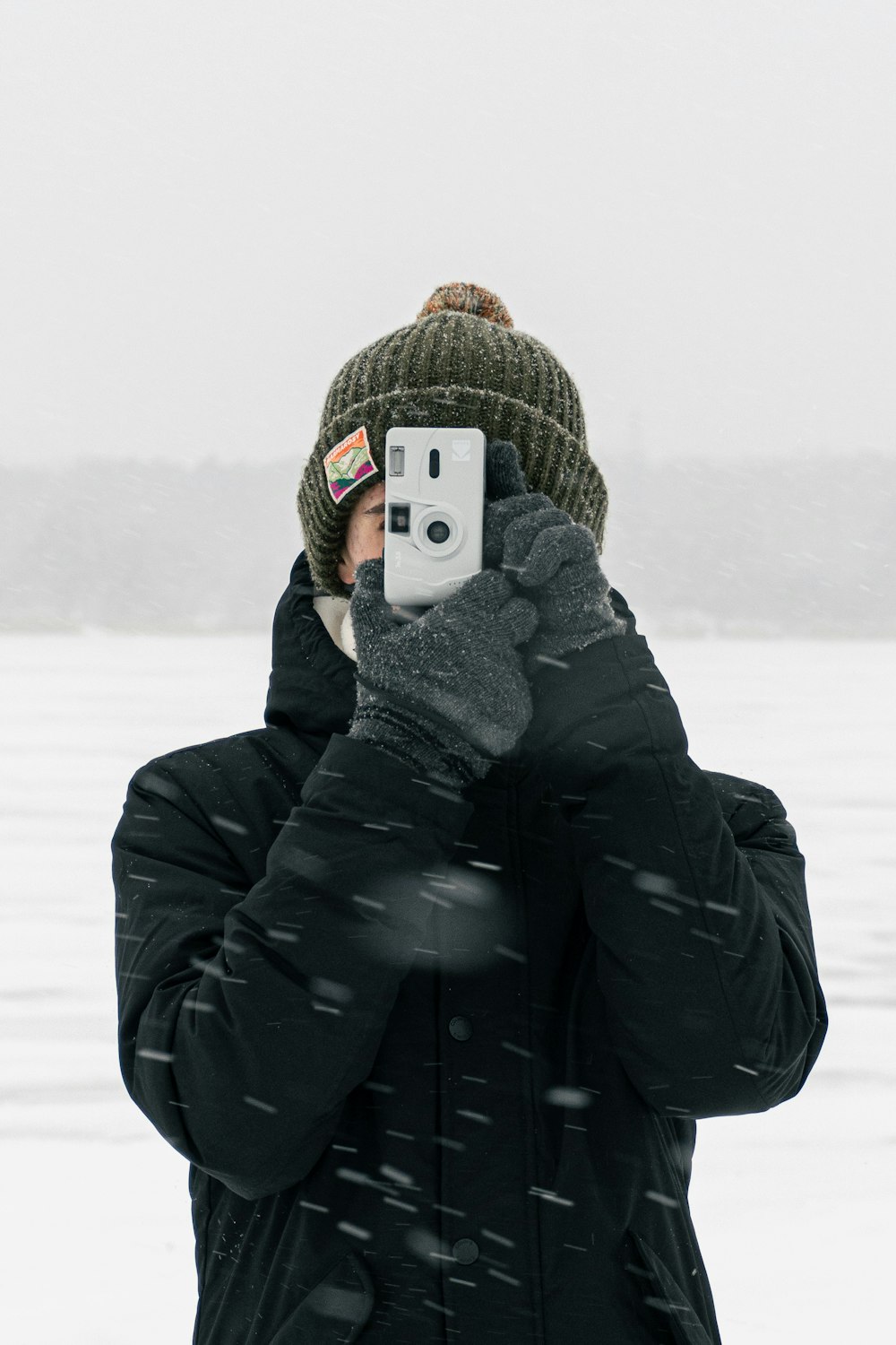 a person taking a picture with a cell phone in the snow