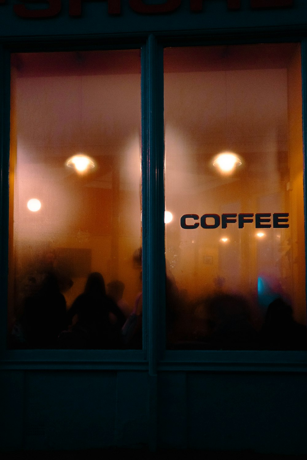 a coffee shop with people sitting in the window