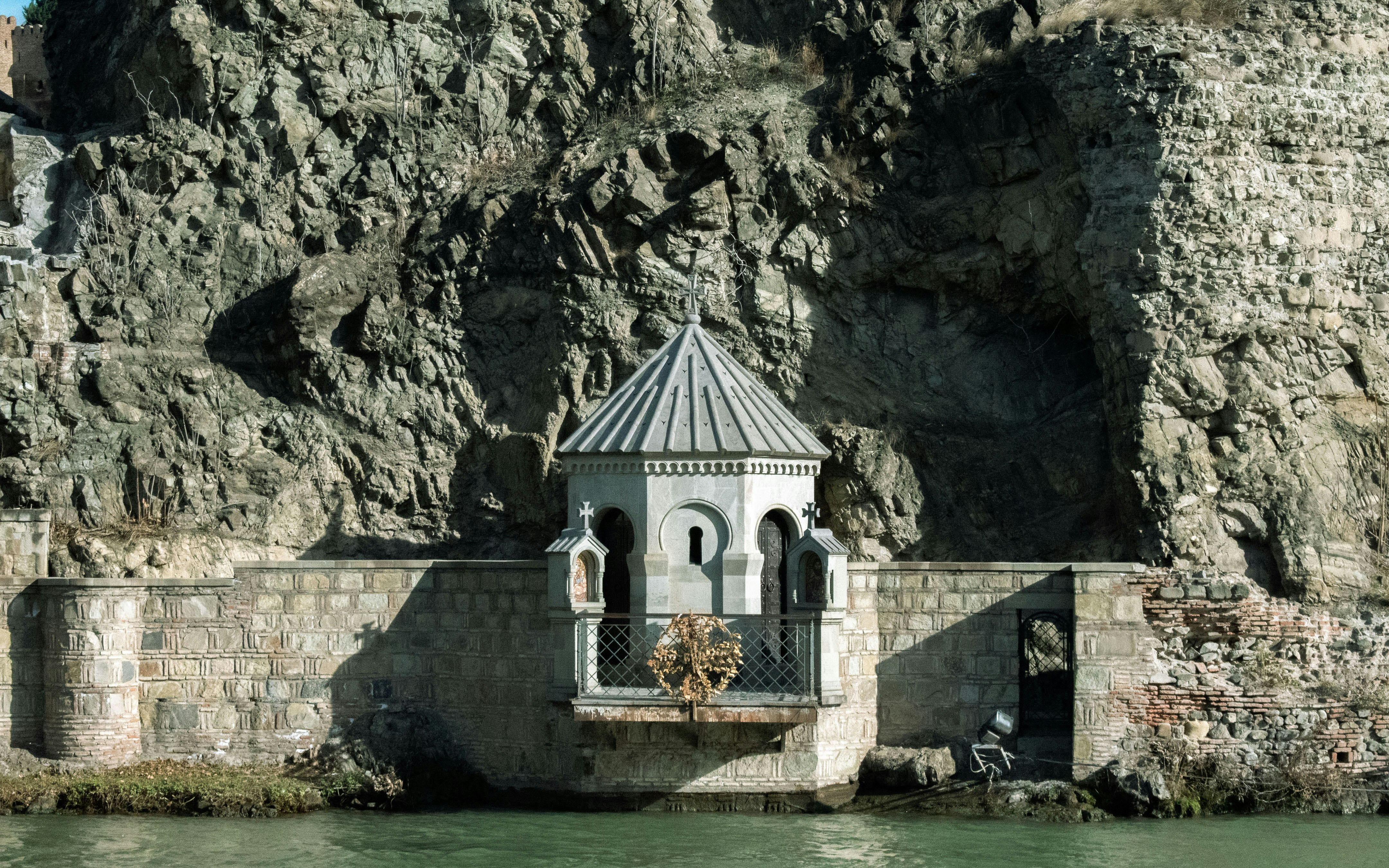 a small white building sitting on the side of a cliff