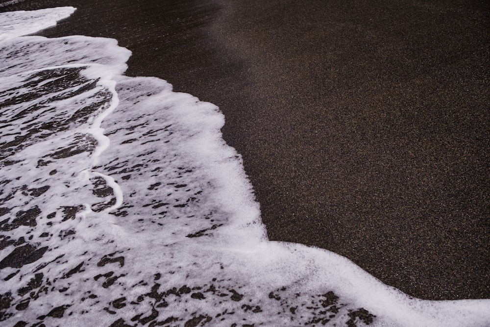 a black sand beach with waves coming in to shore