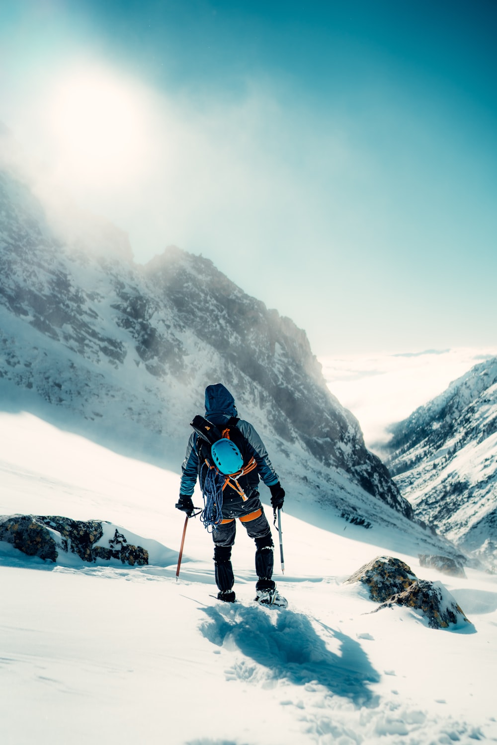 Un hombre subiendo una montaña cubierta de nieve