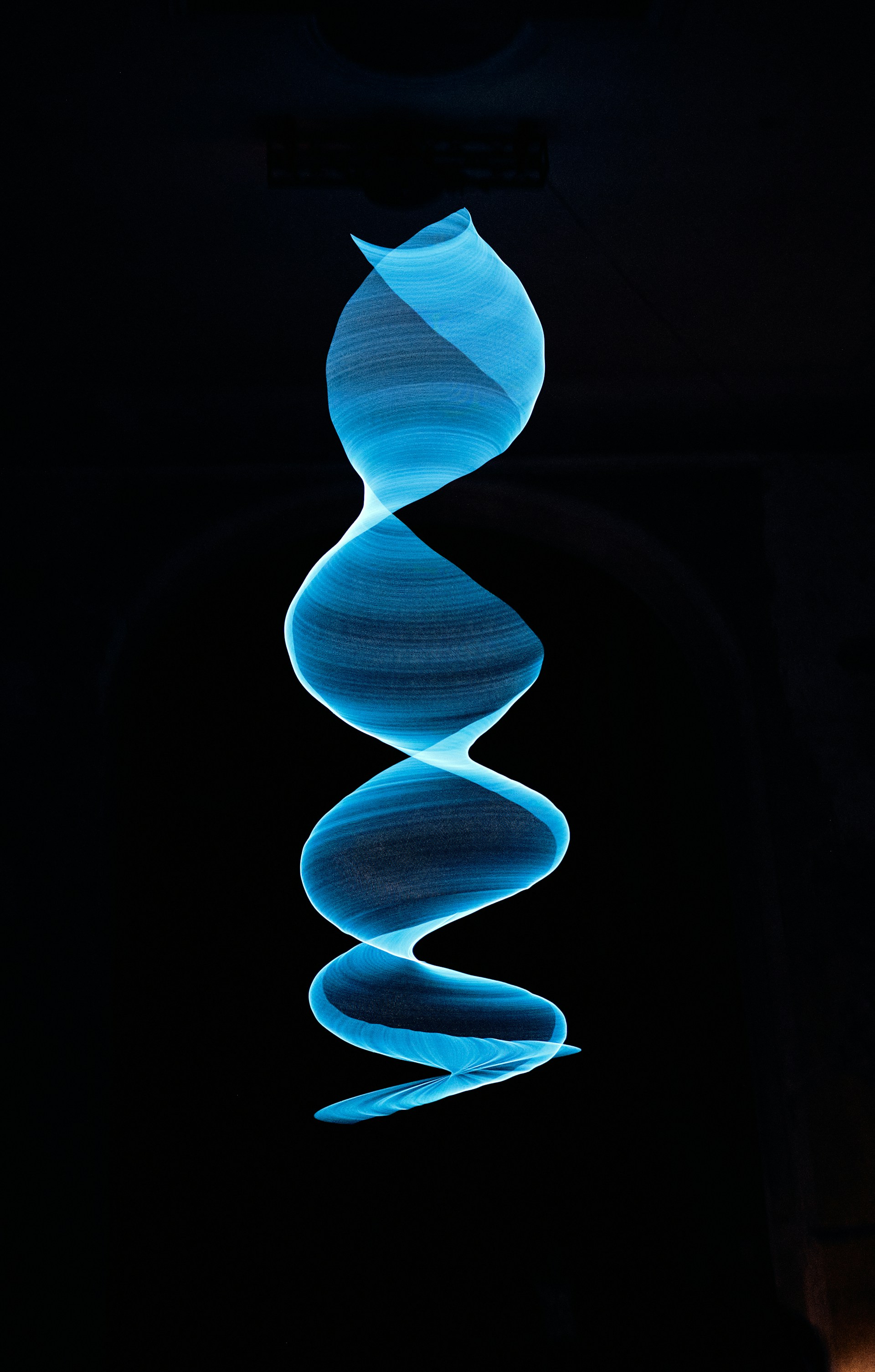 a spiral of blue smoke in the dark