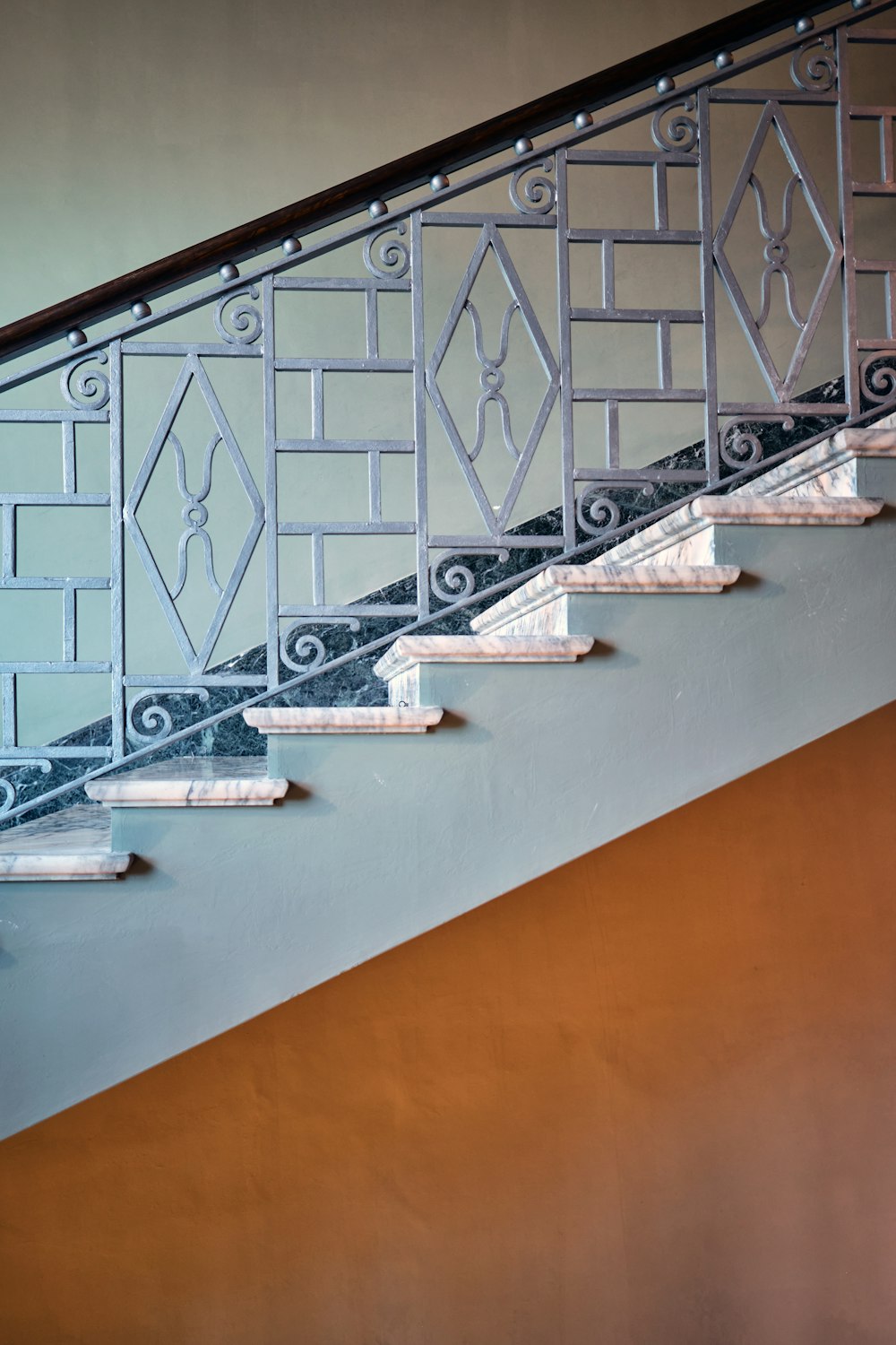 a stair case with wrought iron railing and handrail