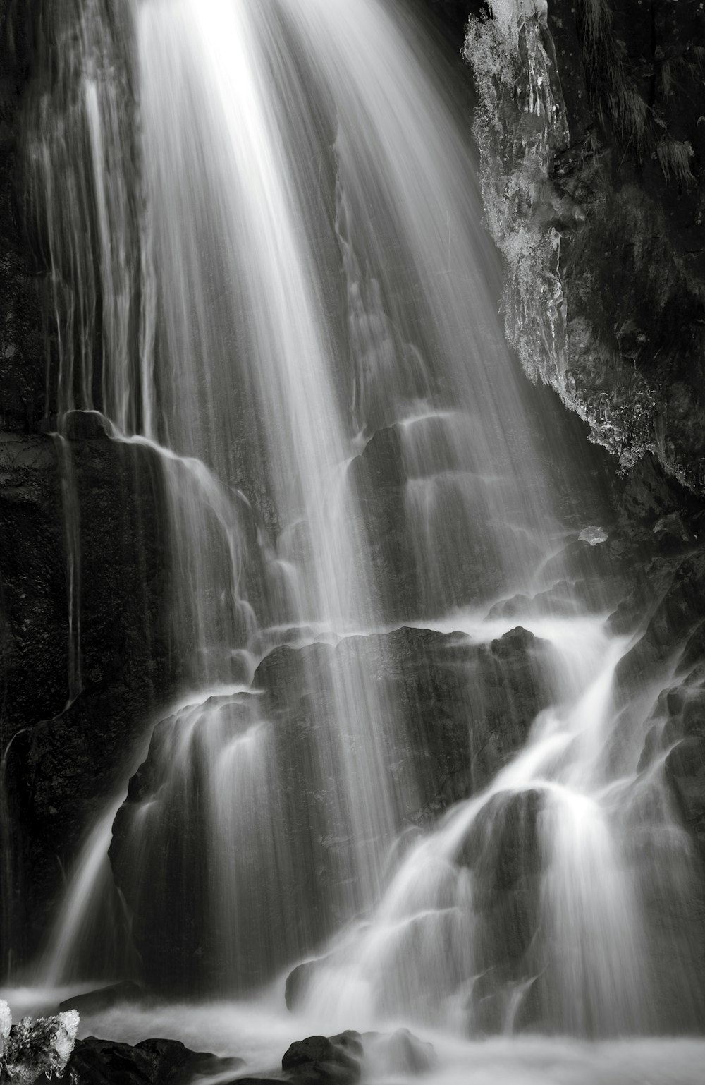 a black and white photo of a waterfall