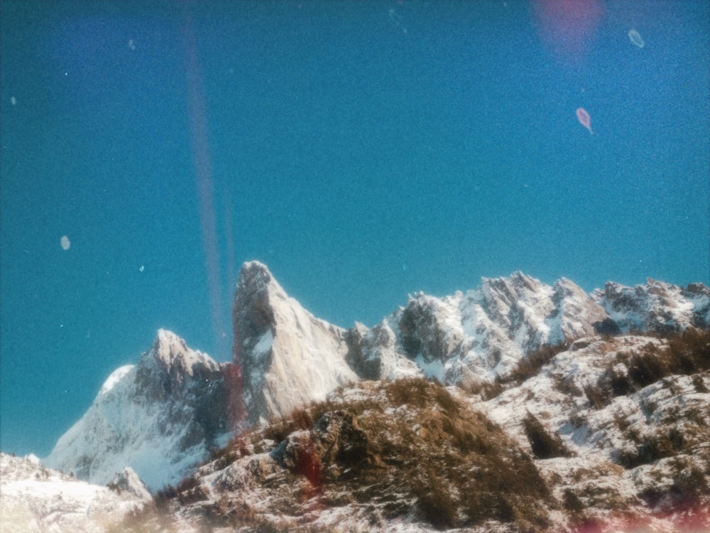 ein schneebedeckter Berg mit blauem Himmel im Hintergrund