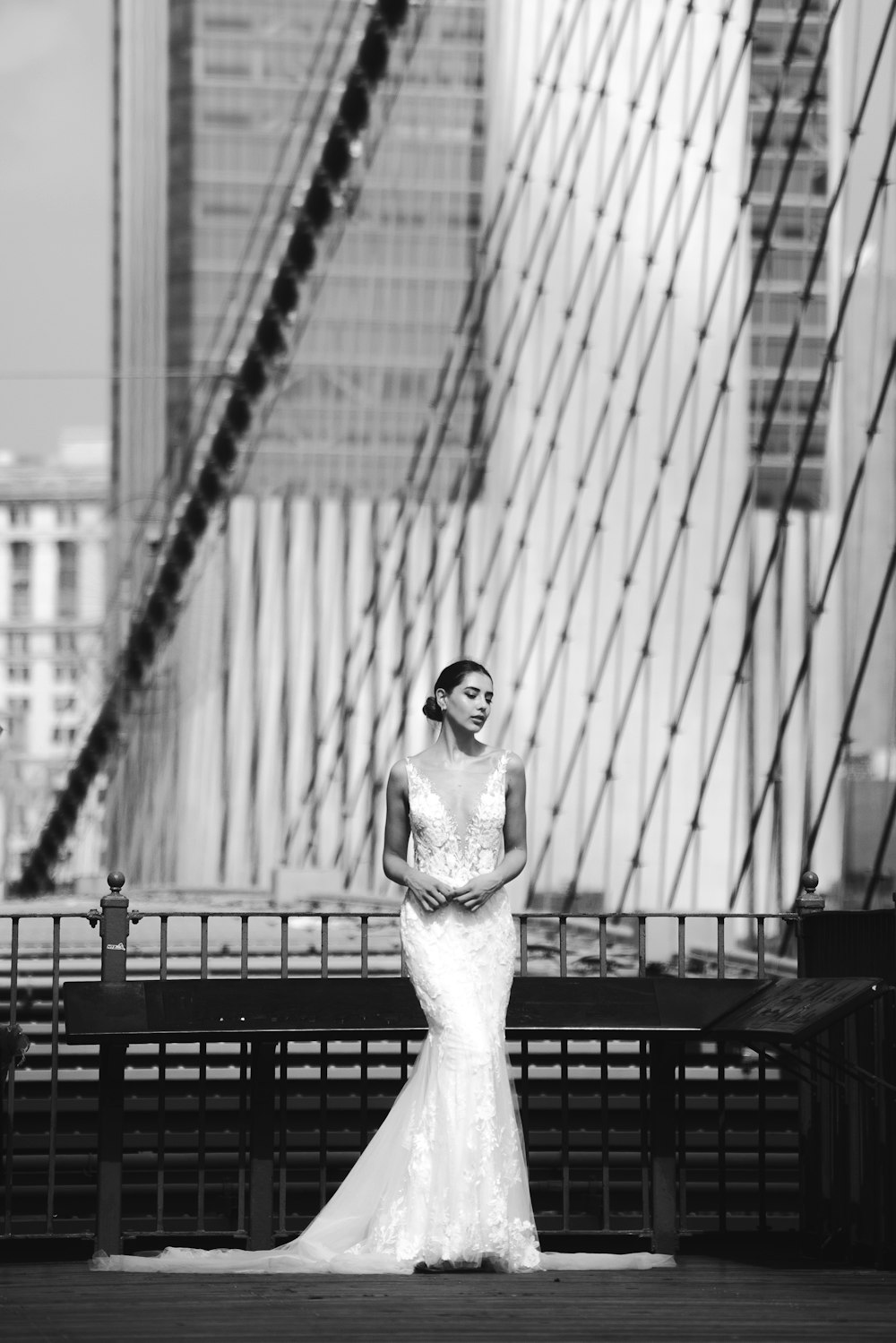 a woman in a wedding dress standing on a bridge