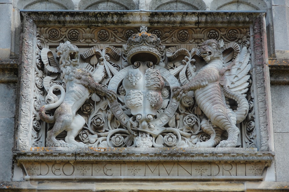 une sculpture d’un lion et de deux autres animaux sur un bâtiment