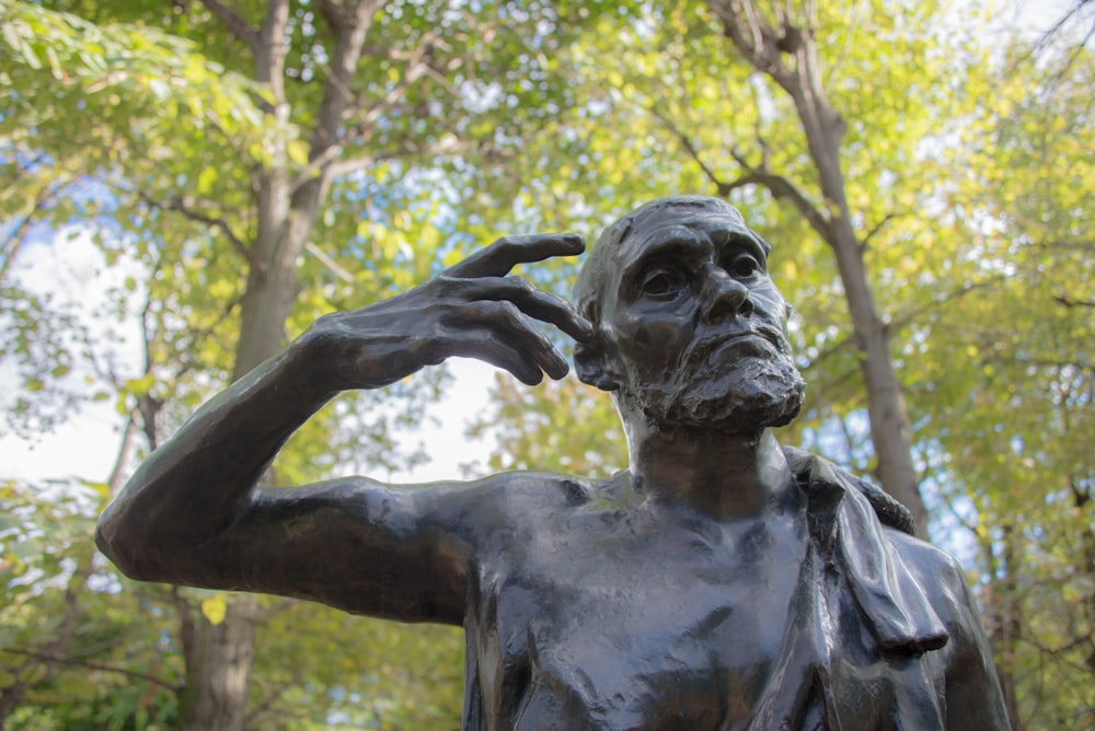 a statue of a man holding his hand to his head