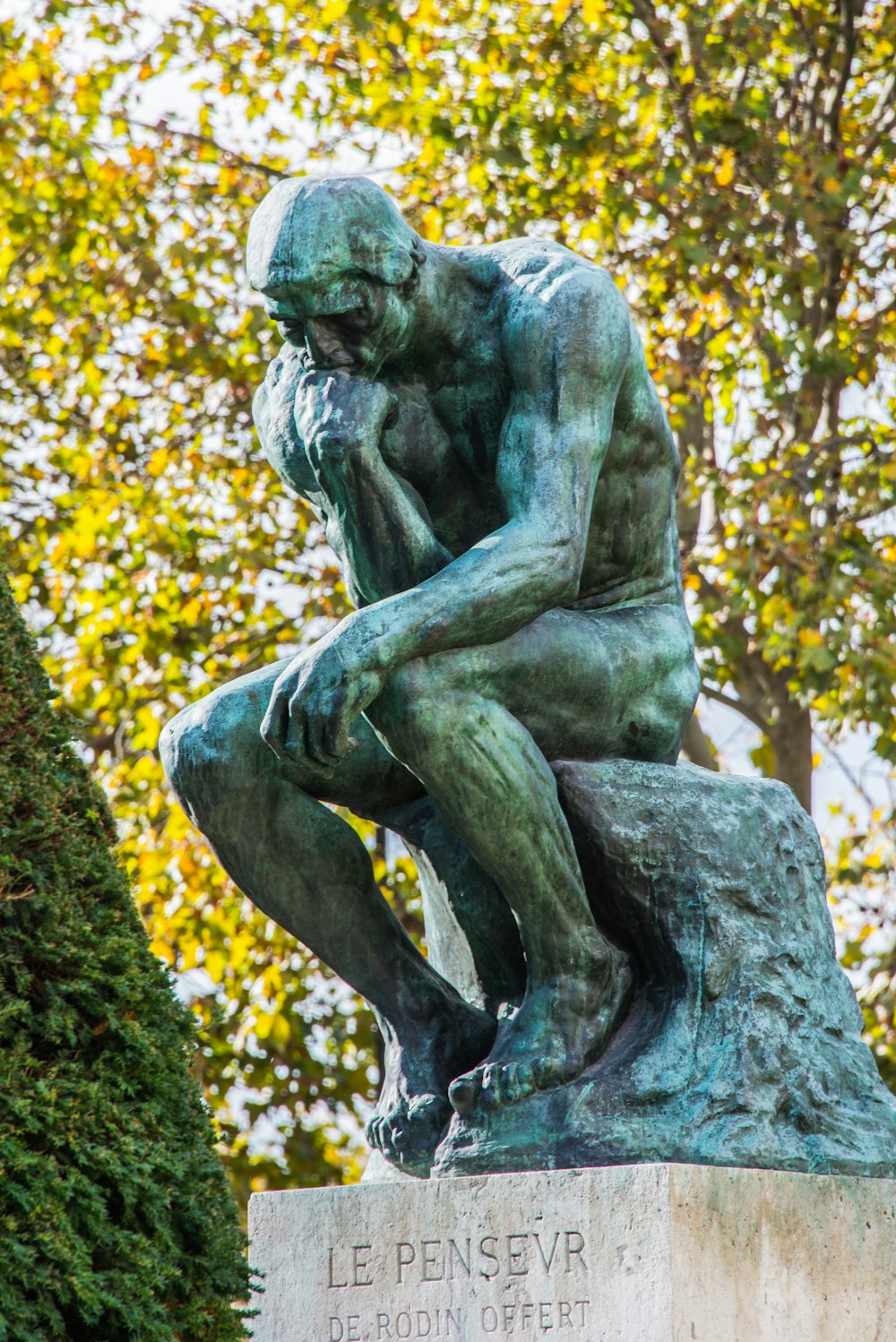 a statue of a man sitting on top of a rock