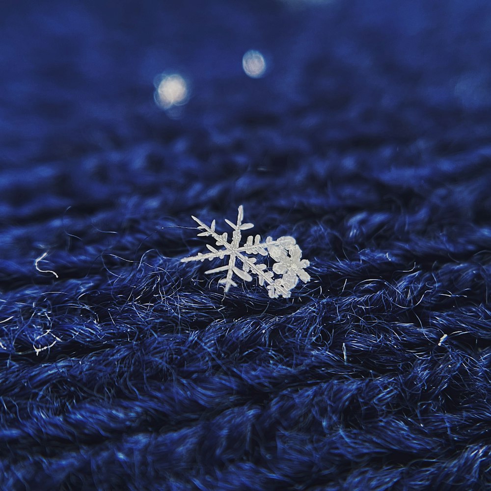 a close up of a snowflake on a blue surface