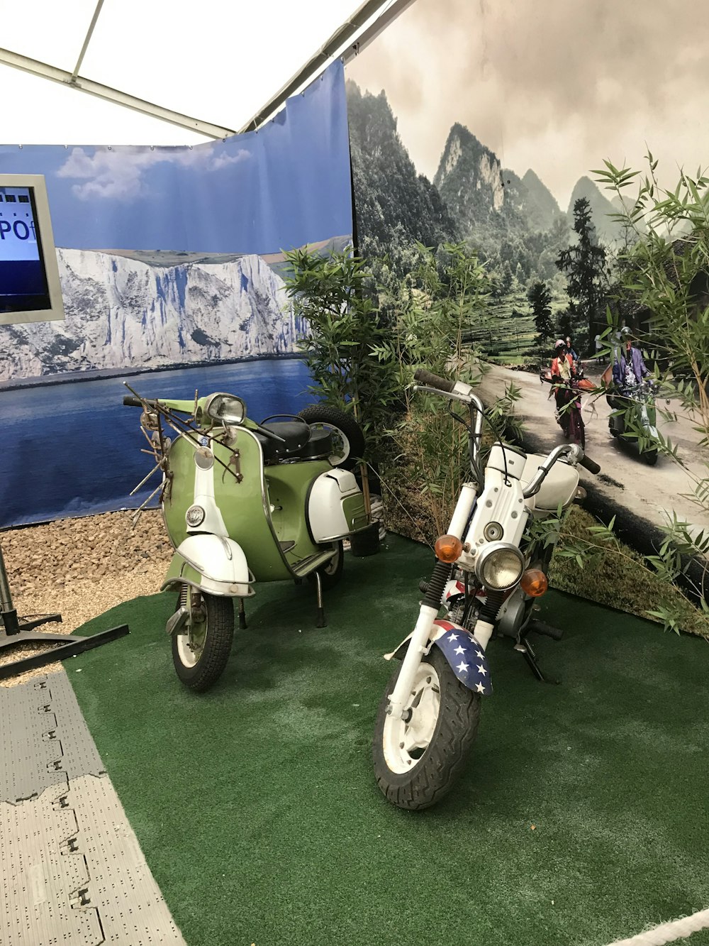 uma scooter e uma motocicleta estão em exposição