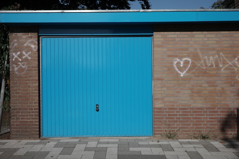 a blue garage door with graffiti on it