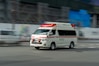 an ambulance driving down a street next to a building
