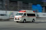 an ambulance driving down a street next to a building
