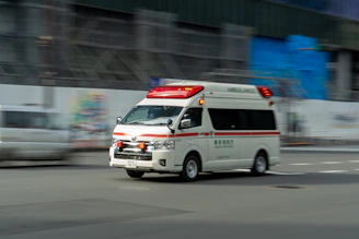 an ambulance driving down a street next to a building
