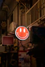 a red smiley face sign hanging from the side of a building
