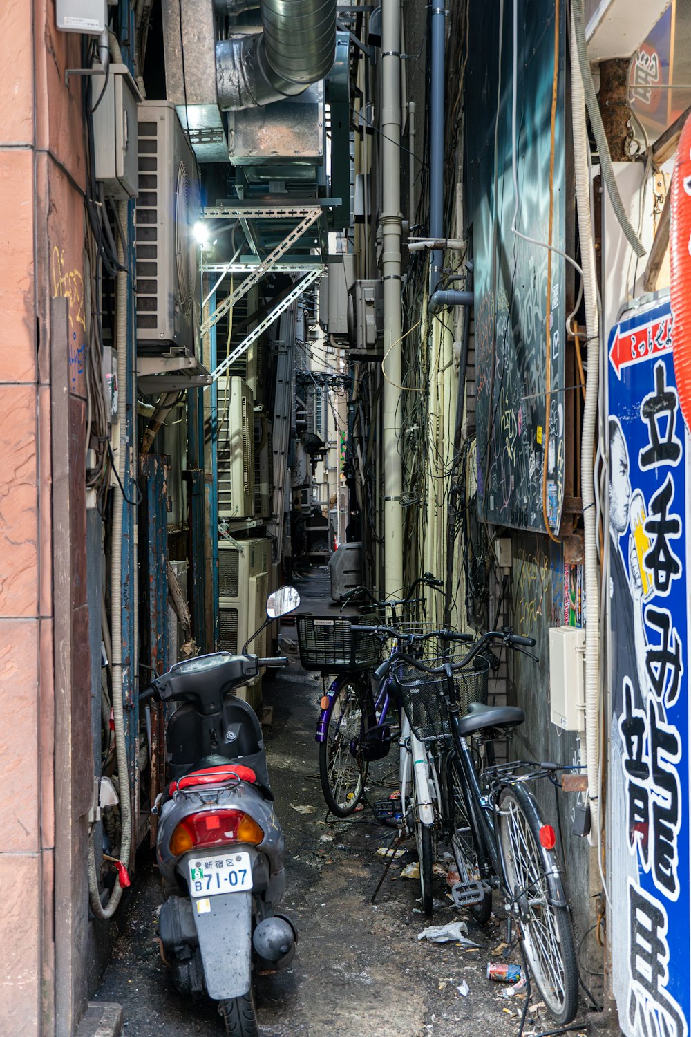 a narrow alley with bikes and scooters parked in it