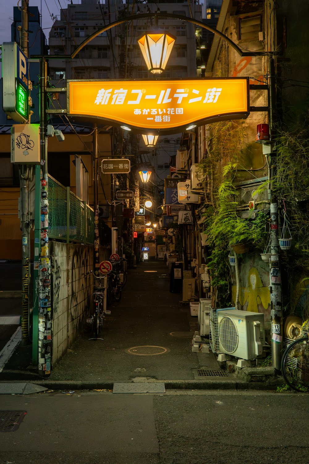 a narrow alley way with a yellow sign above it