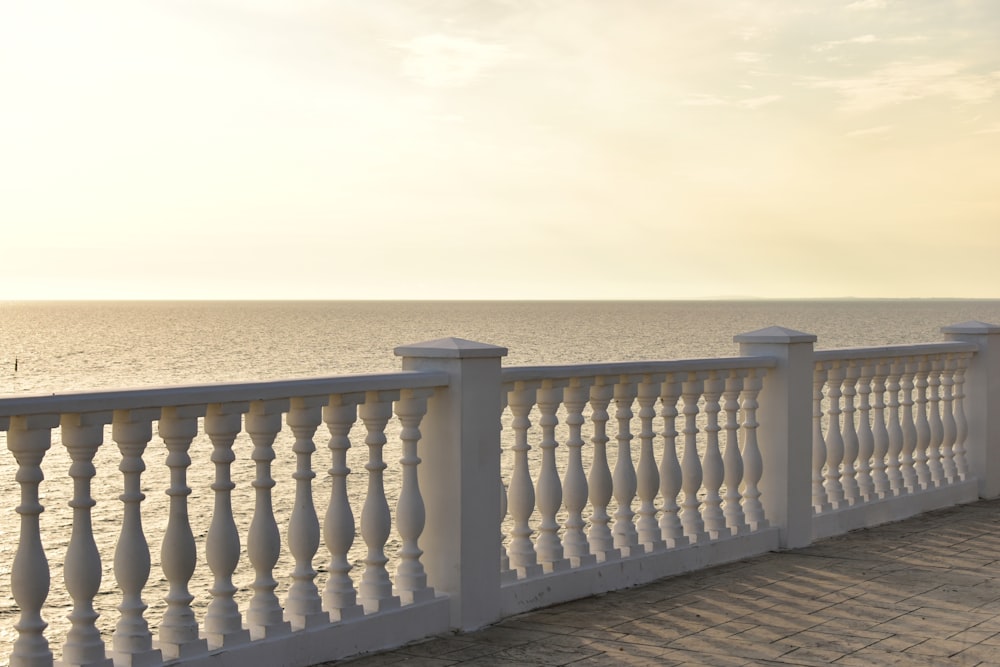 a white balcony overlooking the ocean on a sunny day