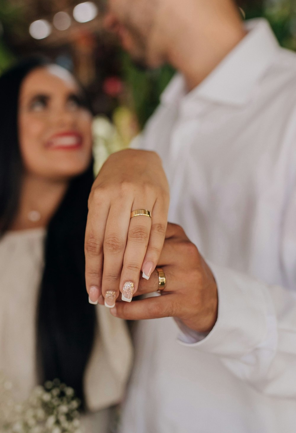 un hombre y una mujer tomados de la mano con anillos de boda