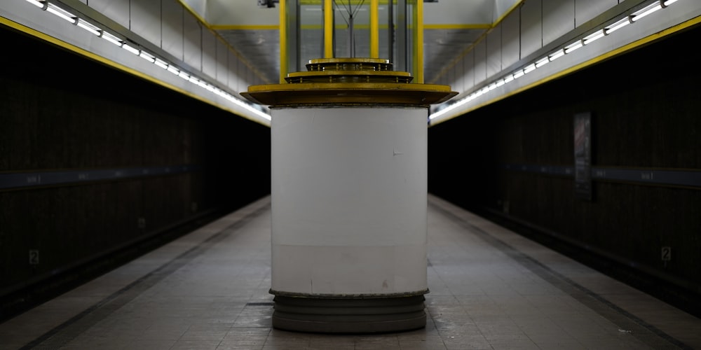 a yellow and white clock on a pole in a tunnel