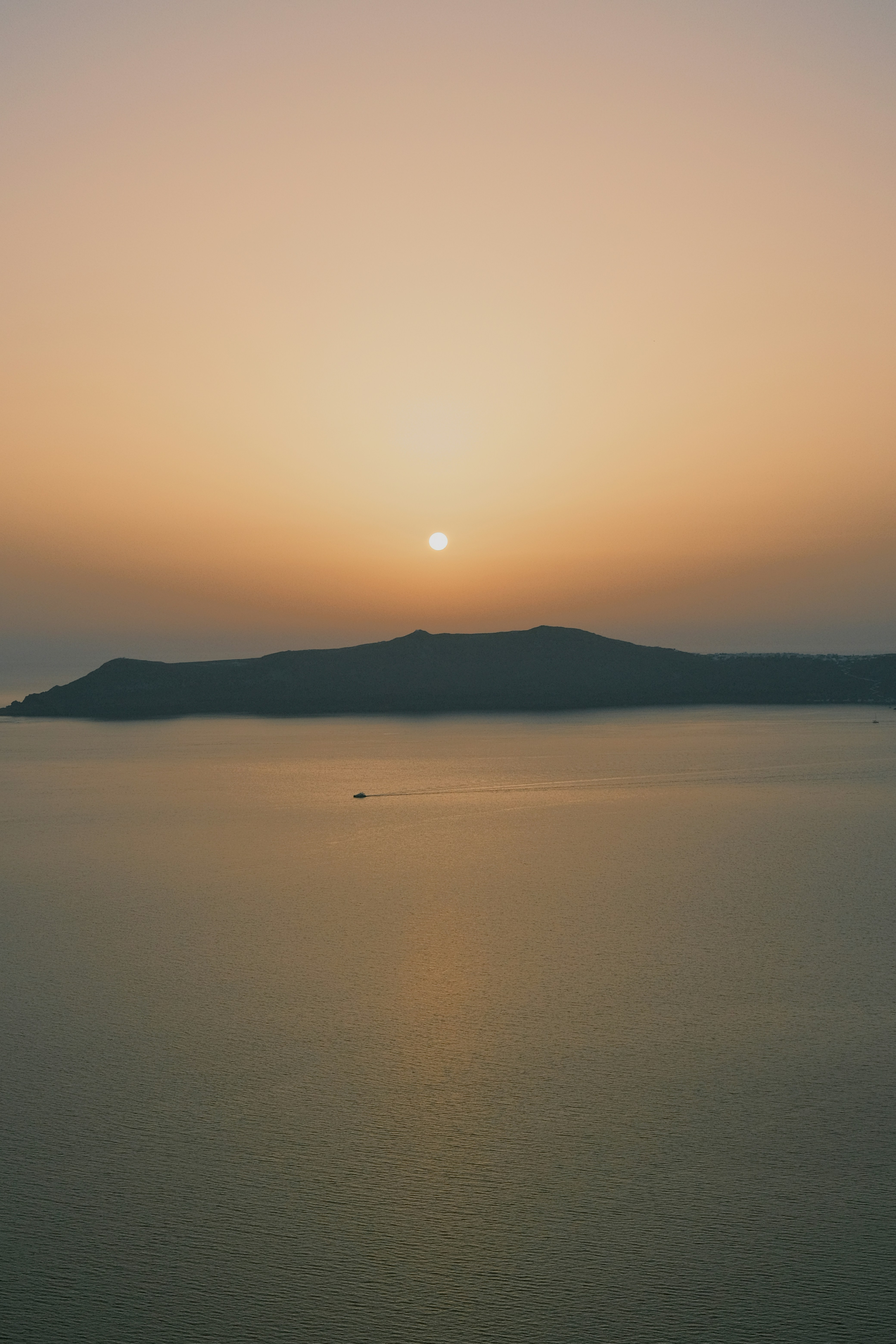 a large body of water with a sunset in the background