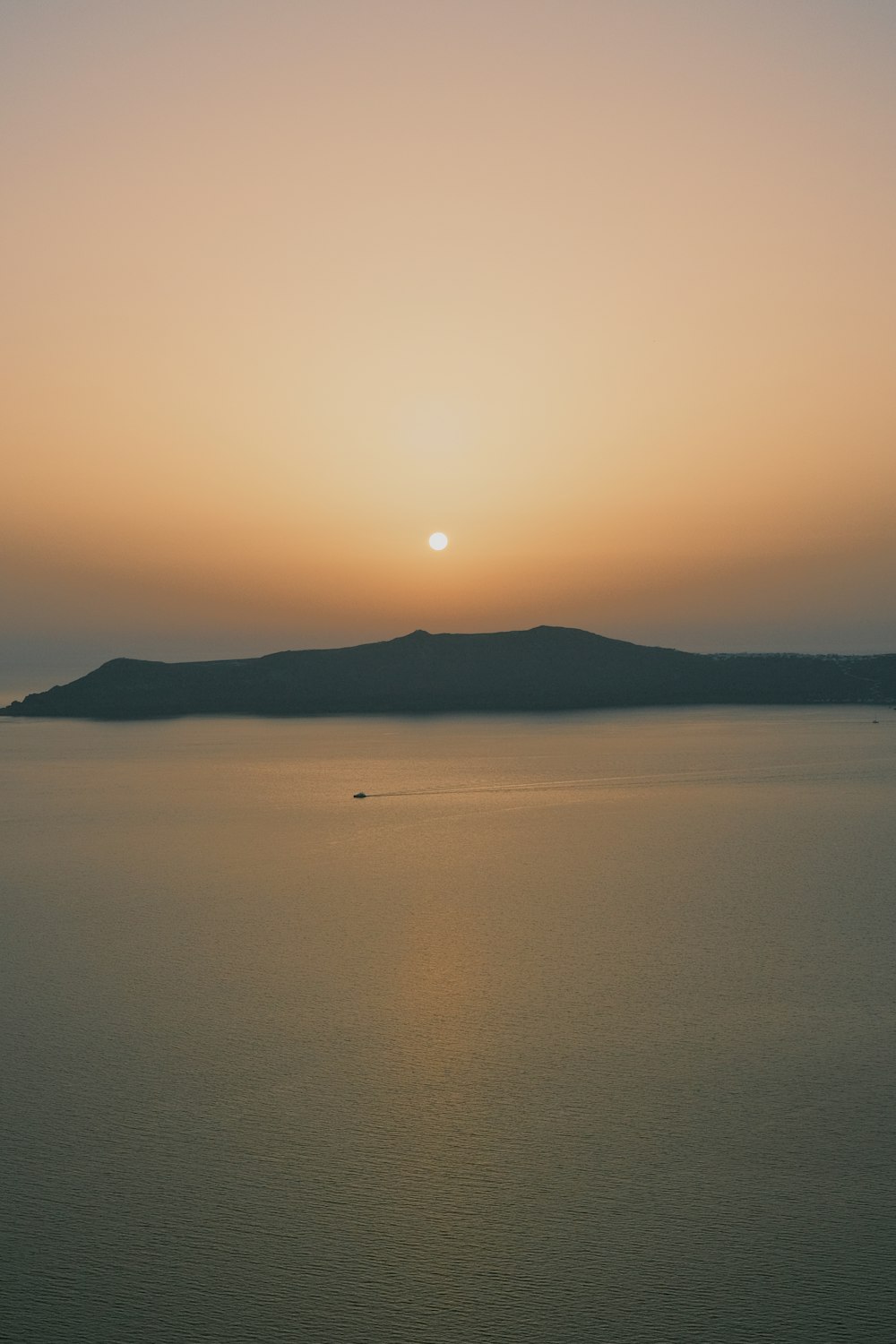 a large body of water with a sunset in the background