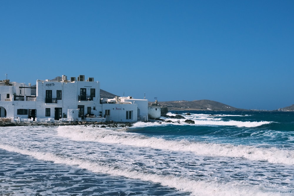 a white house on the shore of the ocean