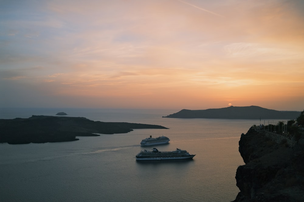 two cruise ships in the water at sunset