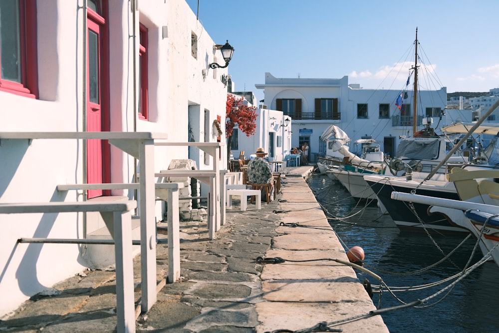 a row of boats docked next to a white building