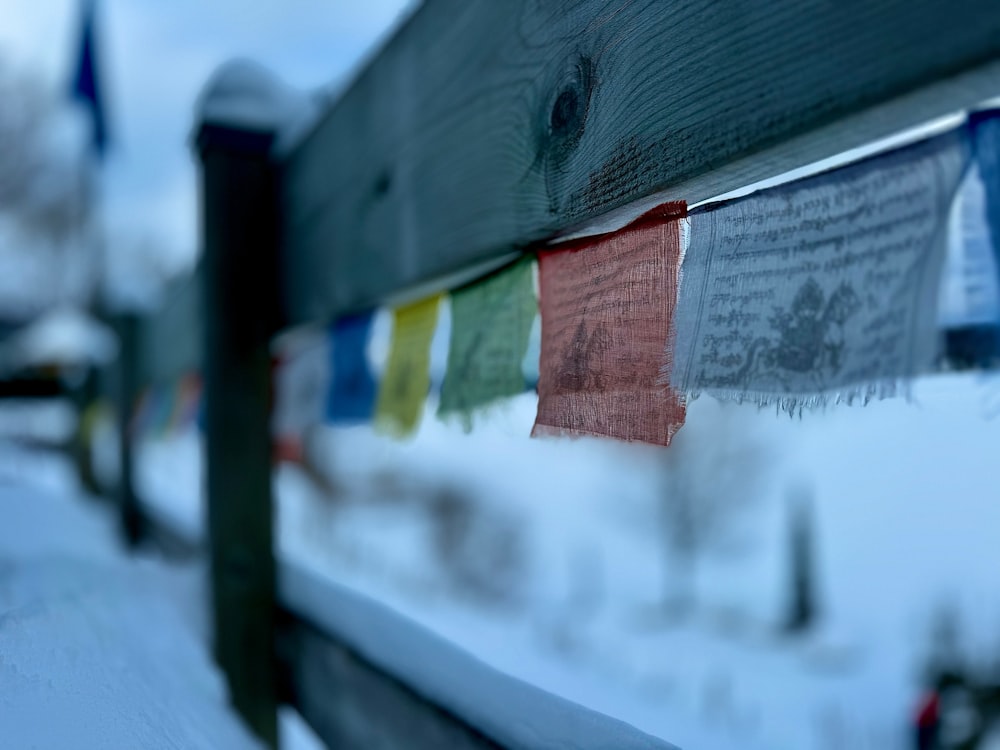 a close up of a wooden bench covered in snow