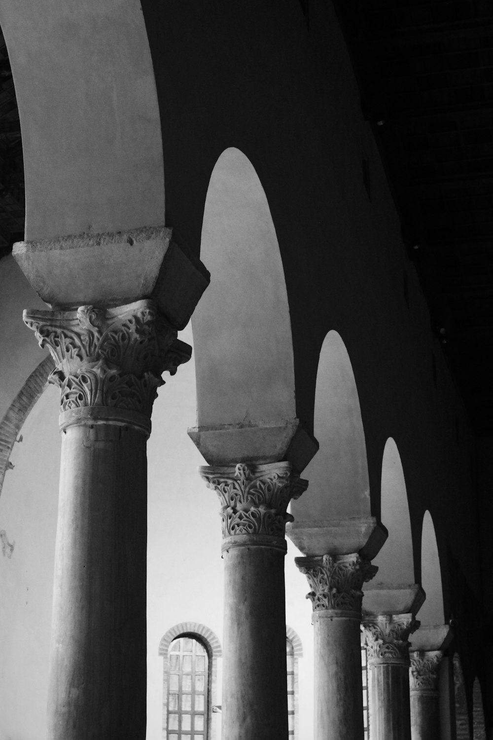 a black and white photo of pillars and windows