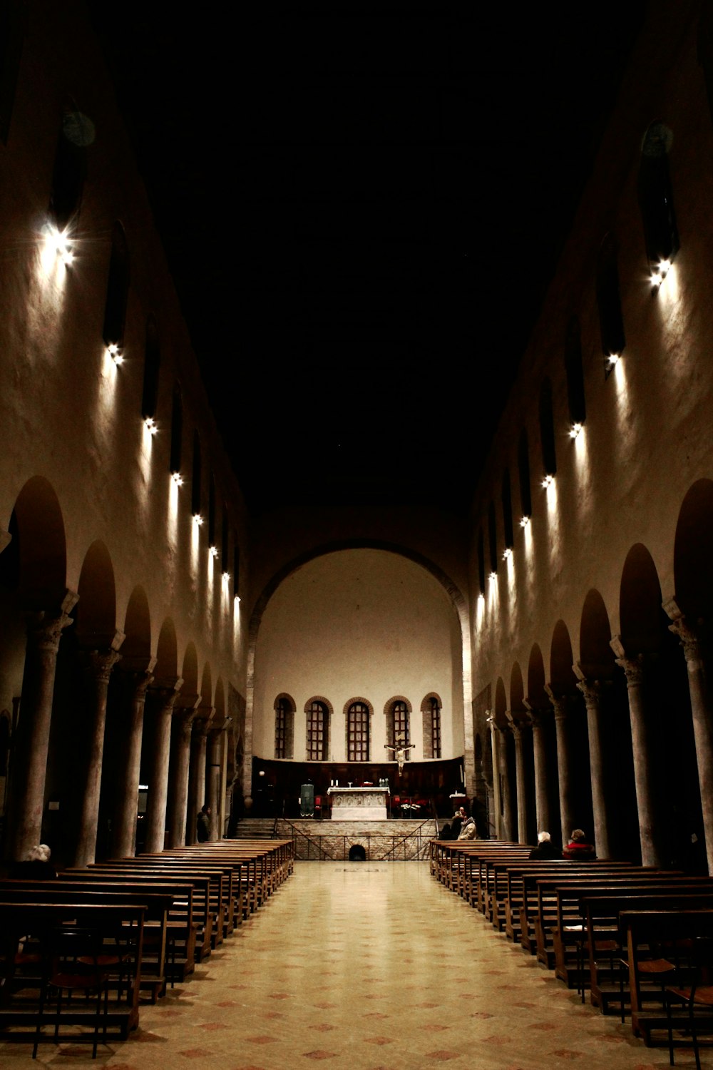 an empty church with rows of pews and lights
