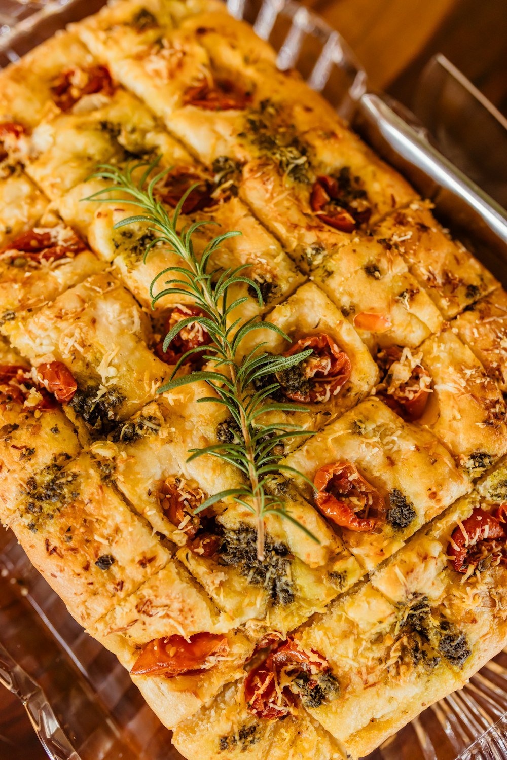 a square casserole with tomatoes and herbs on top