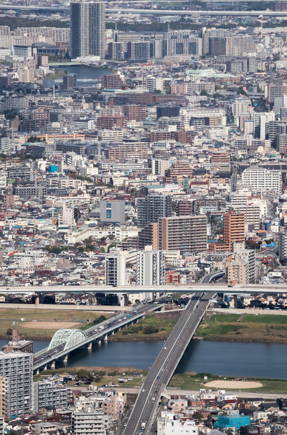 an aerial view of a city with a bridge in the foreground