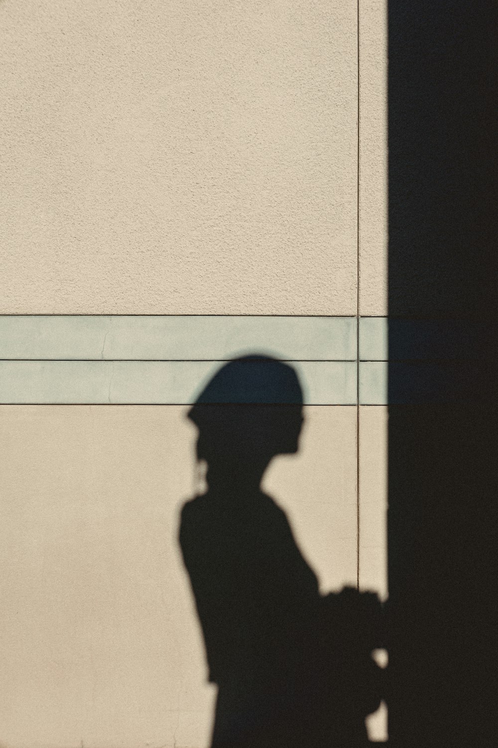 a shadow of a person standing next to a building
