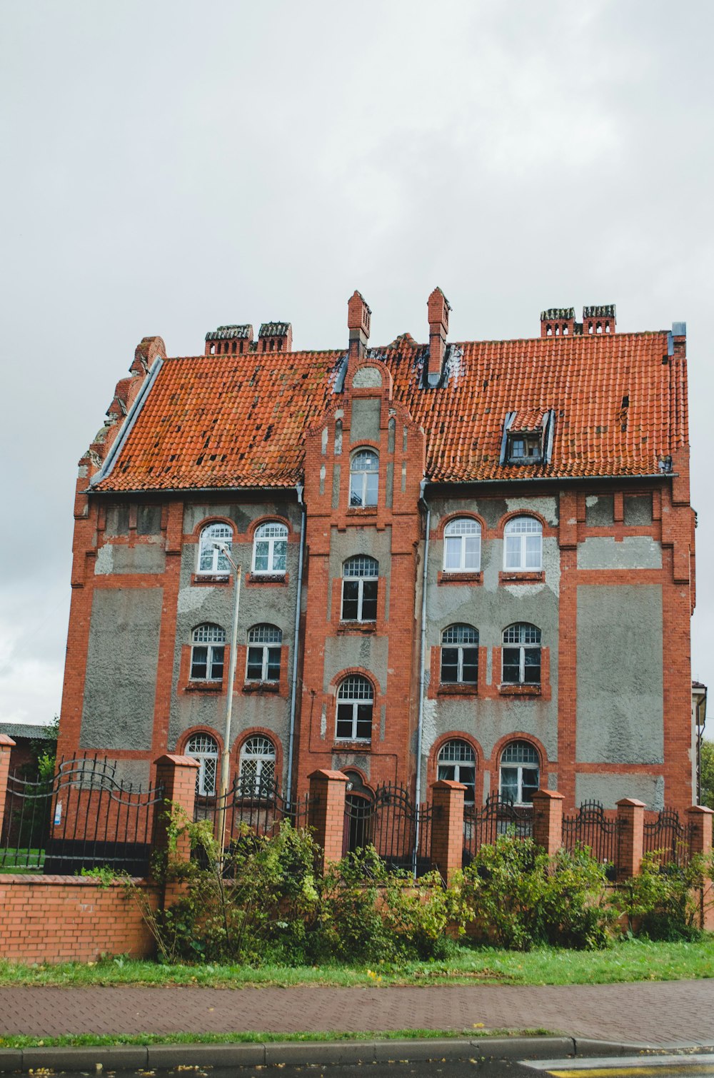 an old brick building with a red tiled roof