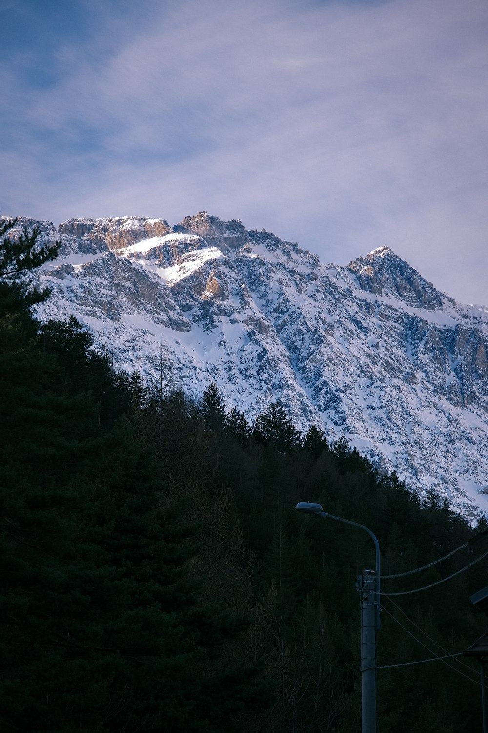 a snow covered mountain with a street light in the foreground