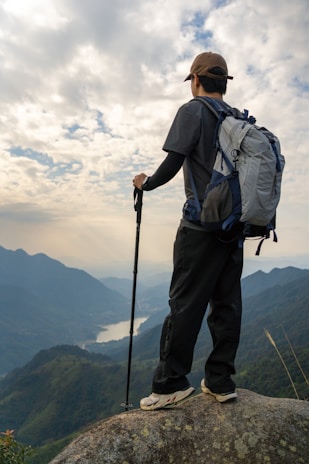 a man standing on top of a mountain with a backpack