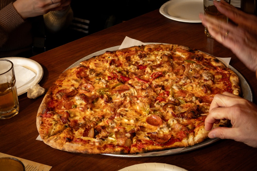 a large pizza sitting on top of a wooden table