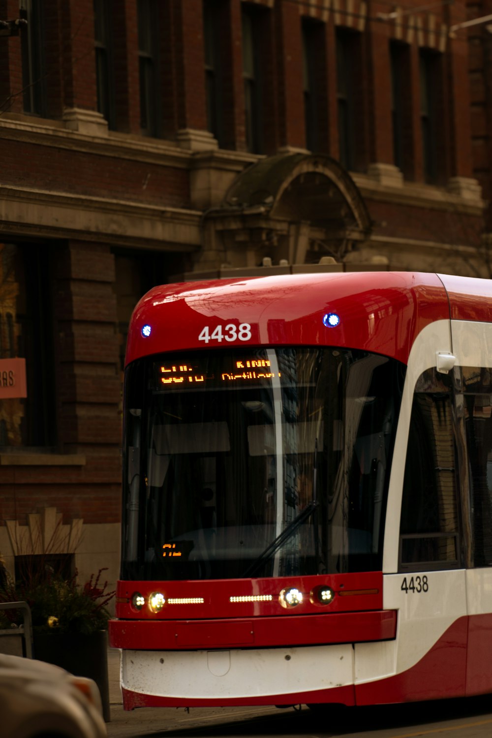 a red and white bus driving down a street