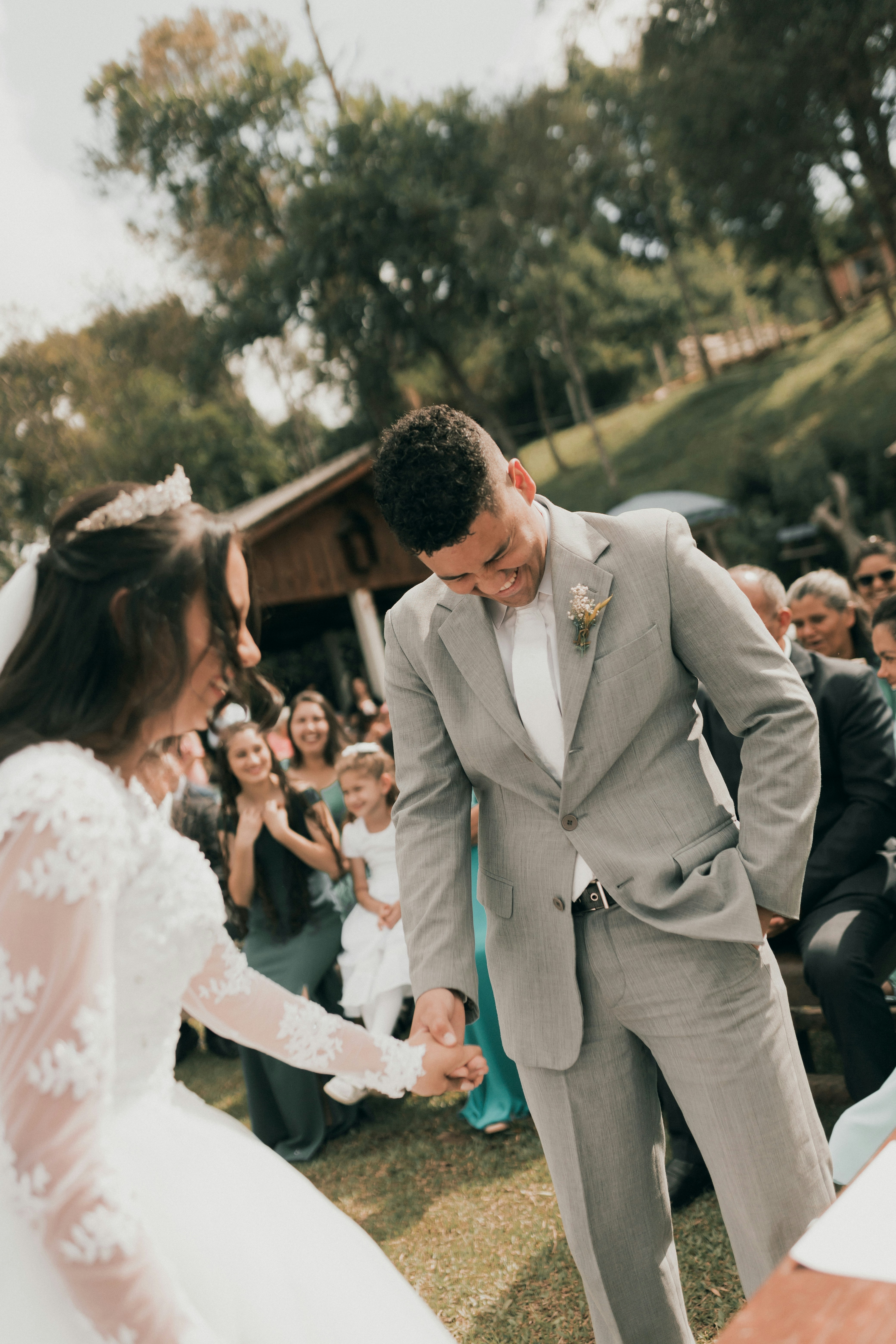 Bride and groom holding hands during an outdoor wedding ceremony.