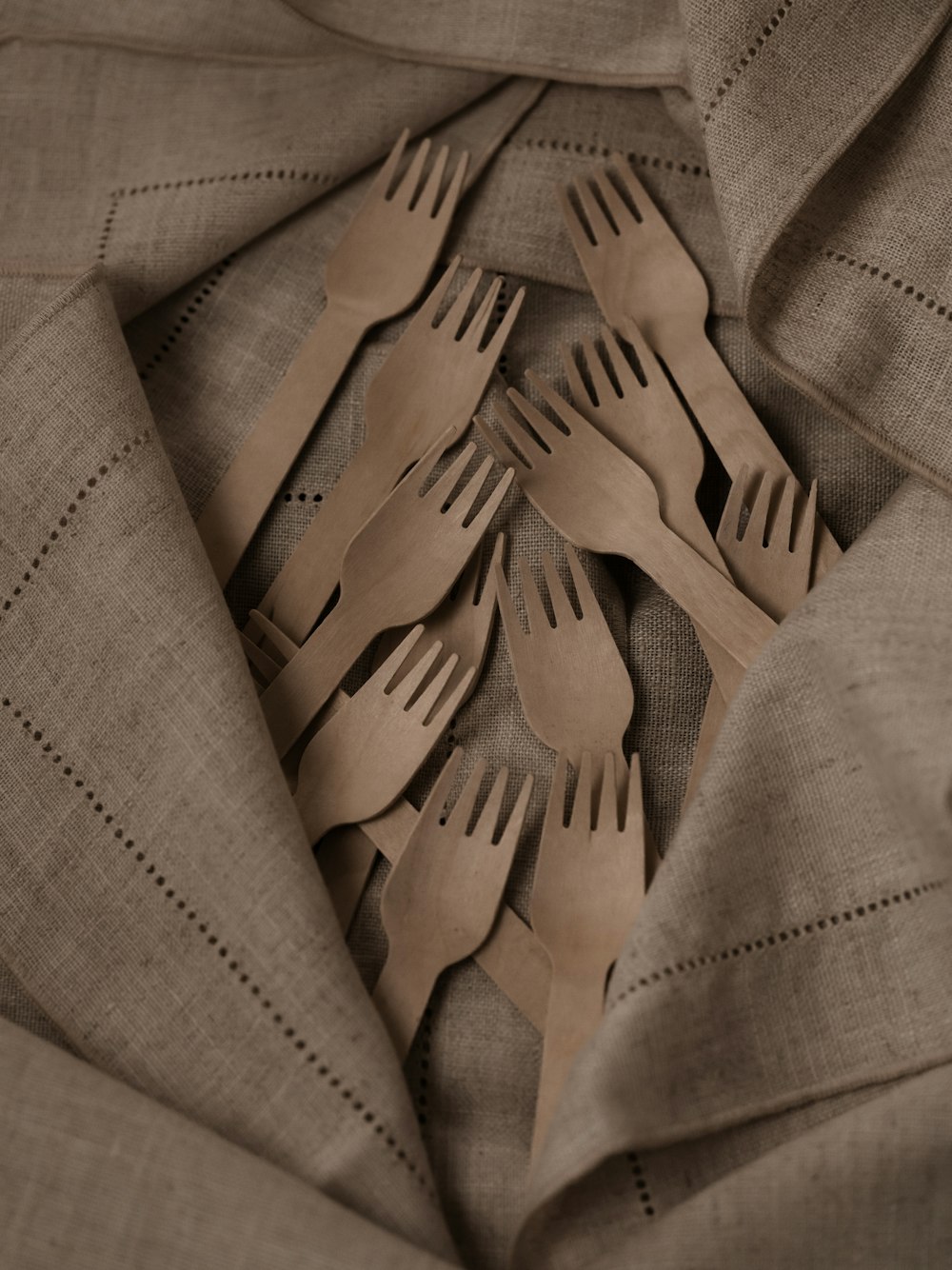 a pile of forks and spoons sitting on top of a cloth