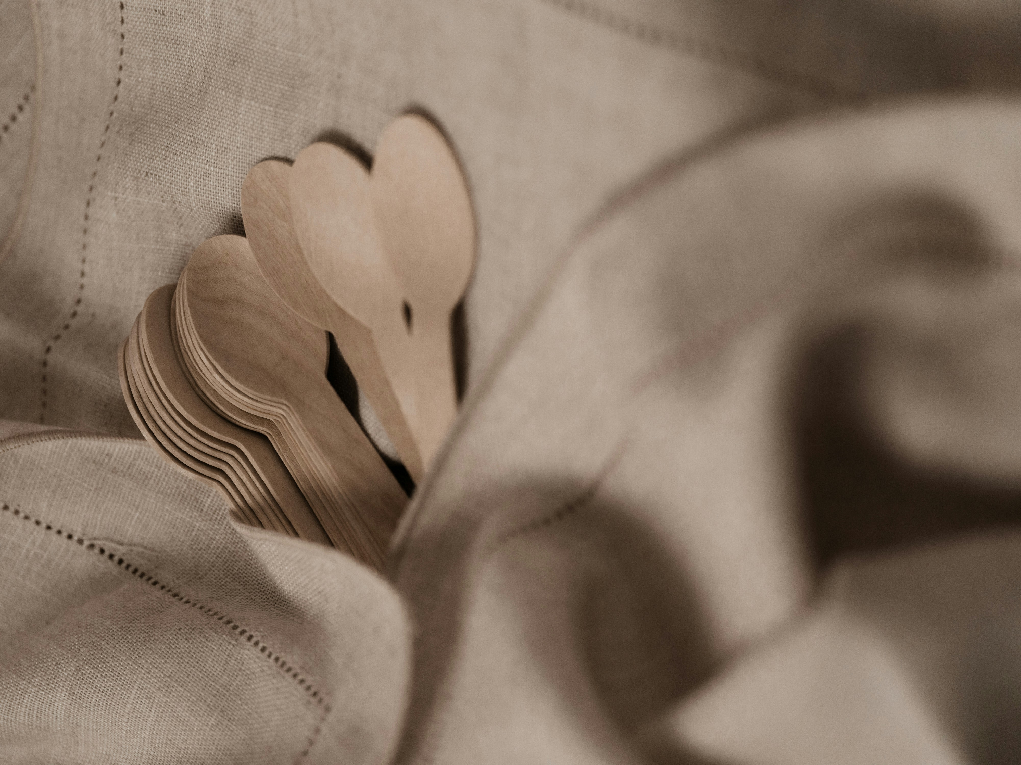 a close up of a cloth with wooden hearts on it